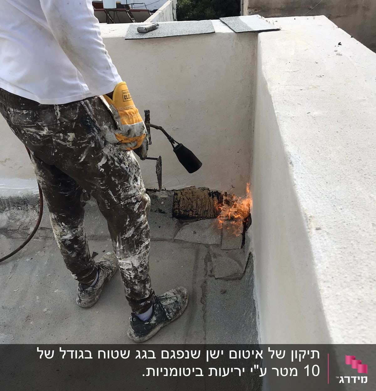 אדם עם מבער מחמם יריעות איטום על גג
